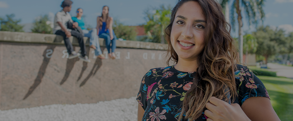 Female student looking and three students sitting in the background